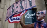 Een demonstrant staat voor de studio in Los Angeles waar Jimmy Kimmel zijn talkshow opneemt. De show van de presentator was ten tijde van het protest  geschorst door de zender ABC na grappen over de vermoorde rechtse activist en Trump-aanhanger Charlie Kirk.