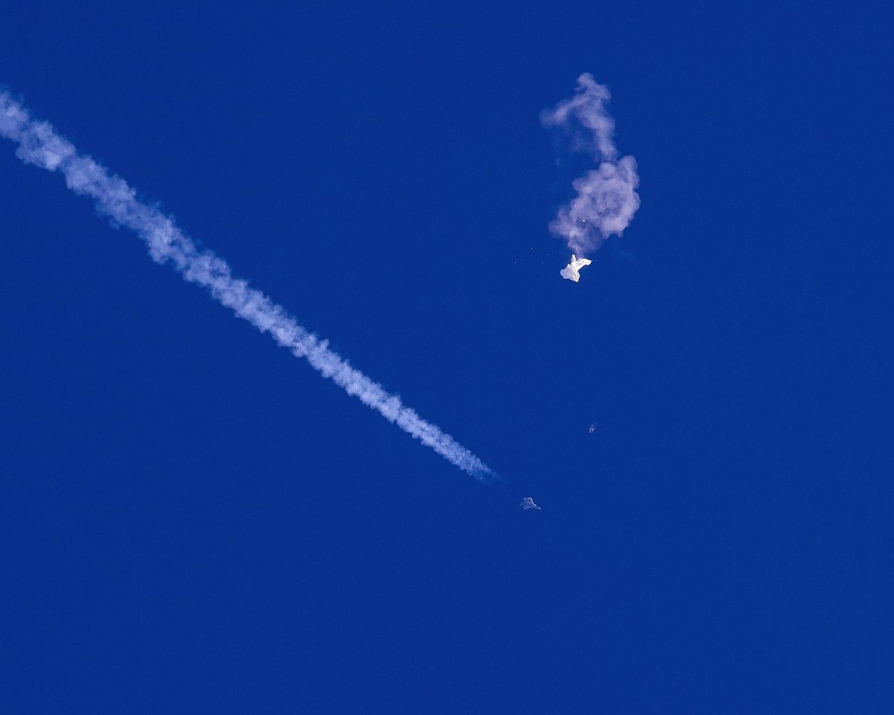 Restanten van de Chinese ballon op bijna twintig kilometer hoogte, kort nadat deze zaterdag boven zee werd getroffen door een raket van een Amerikaans gevechtsvliegtuig