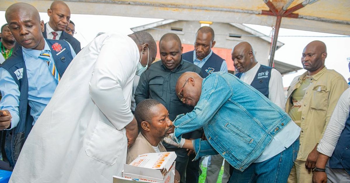 De Congolese minister van Volksgezondheid Roger Kamba (in spijkerjas) dient een ebolavaccin toe aan een zorgmedewerker in