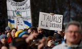 Ein Demonstrant hält in Berlin ein Schild hoch, auf dem er die Bundesregierung auffordert, die Ukraine Ende Februar mit Taurus-Marschflugkörpern zu beliefern.