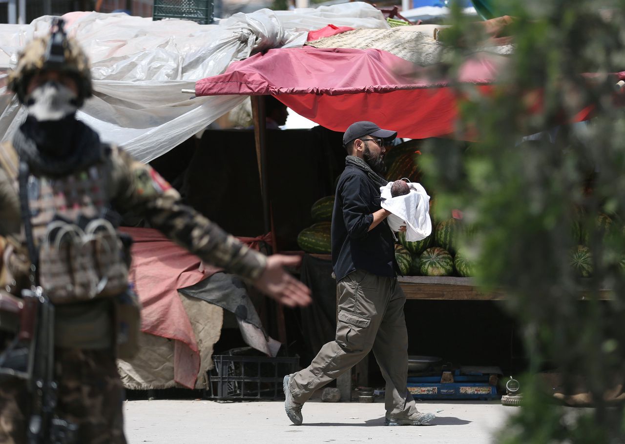 Een militair draagt na de aanslag een baby weg bij de kraamkliniek.