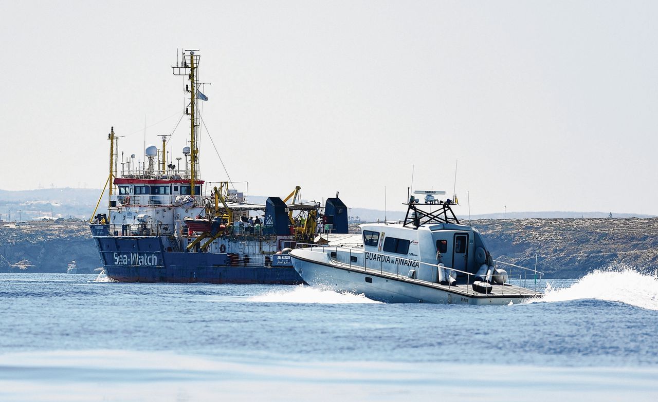 De Sea Watch met bootmigranten en de Italiaanse politie bij Lampedusa.