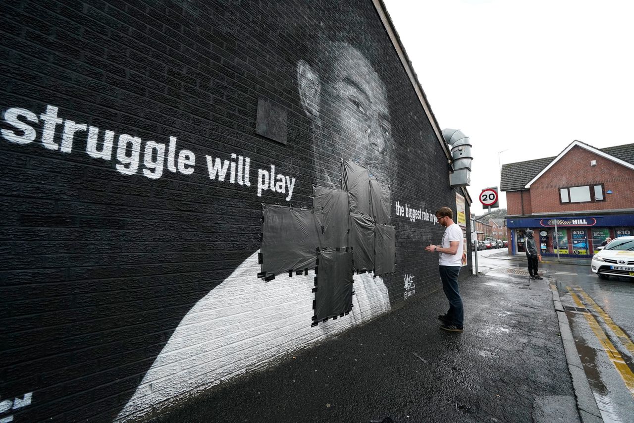 Inwoners van Manchester plakten maandag steunbetuigingen over racistische teksten heen op een portret van Marcus Rashford.