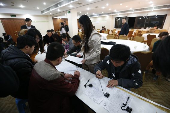 Chinese familieleden van passagiers van het vermiste vliegtuig vullen formulieren in op het vliegveld in Beijing.