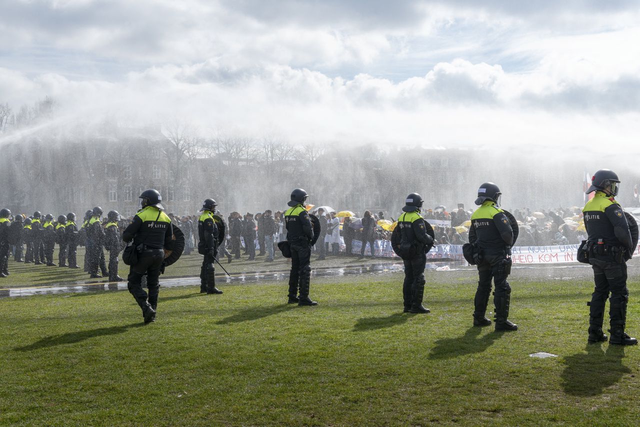 Politie-agenten treden op bij een demonstratie tegen de coronamaatregelen op het Museumplein in Amsterdam, 20 maart 2021.