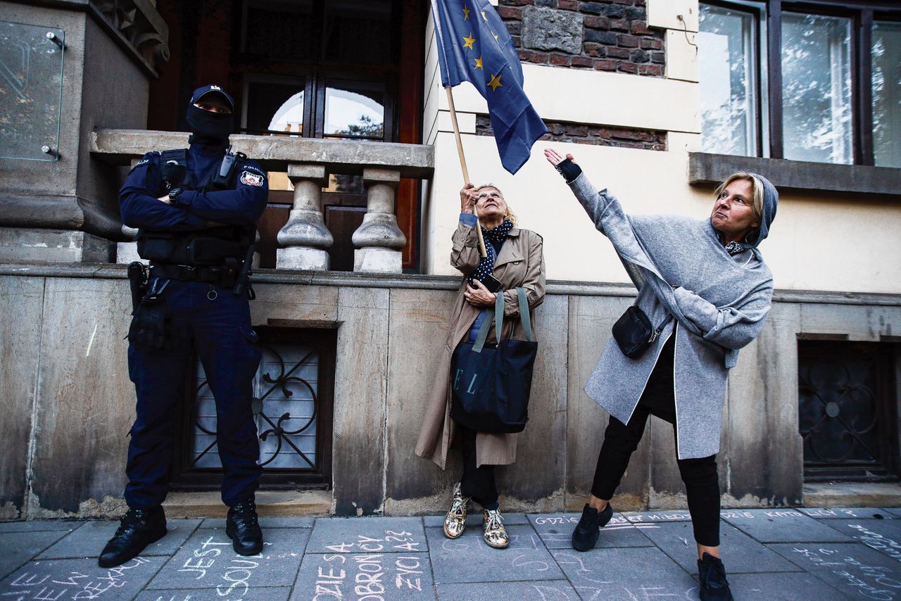 Twee vrouwen zwaaien met een EU-vlag bij een demonstratie tegen de beslissing van het Constitutioneel Hof, dat het Poolse recht boven het Europees recht stelde.