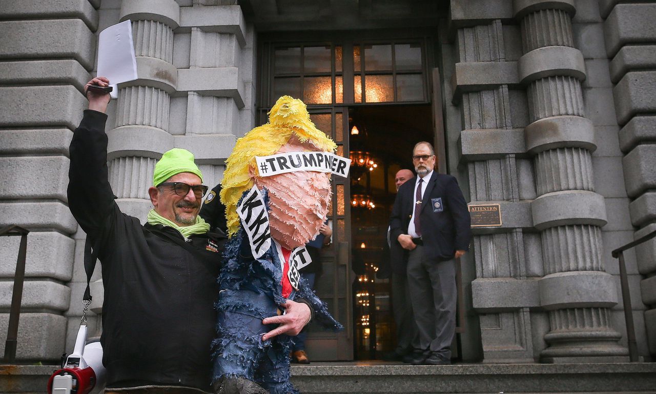 Een tegenstander van het inreisverbod houdt een kopie omhoog van de uitspraak van het federaal Hof van Beroep in San Francisco.