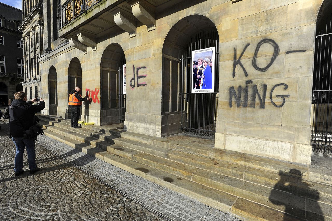 Medewerkers van de gemeente zijn bezig de woorden ' Fuck de Koning' van de muren van het Paleis op de Dam te verwijderen. De leus werd door onbekenden het gebouw gespoten.