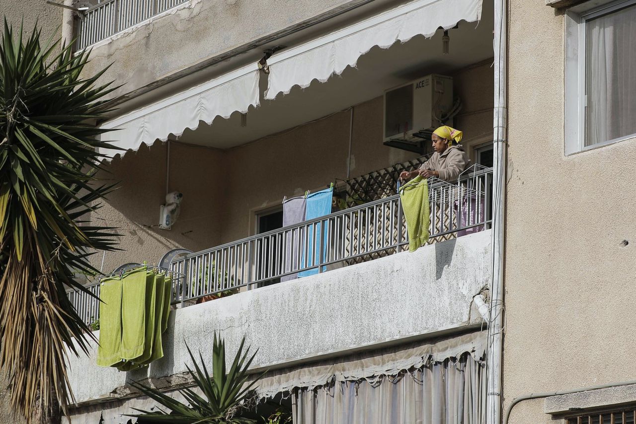 Een huishoudster hangt de was uit over het balkon van het appartement waar ze werkt, in de stad Dbayeh, ten noorden van Beirut.