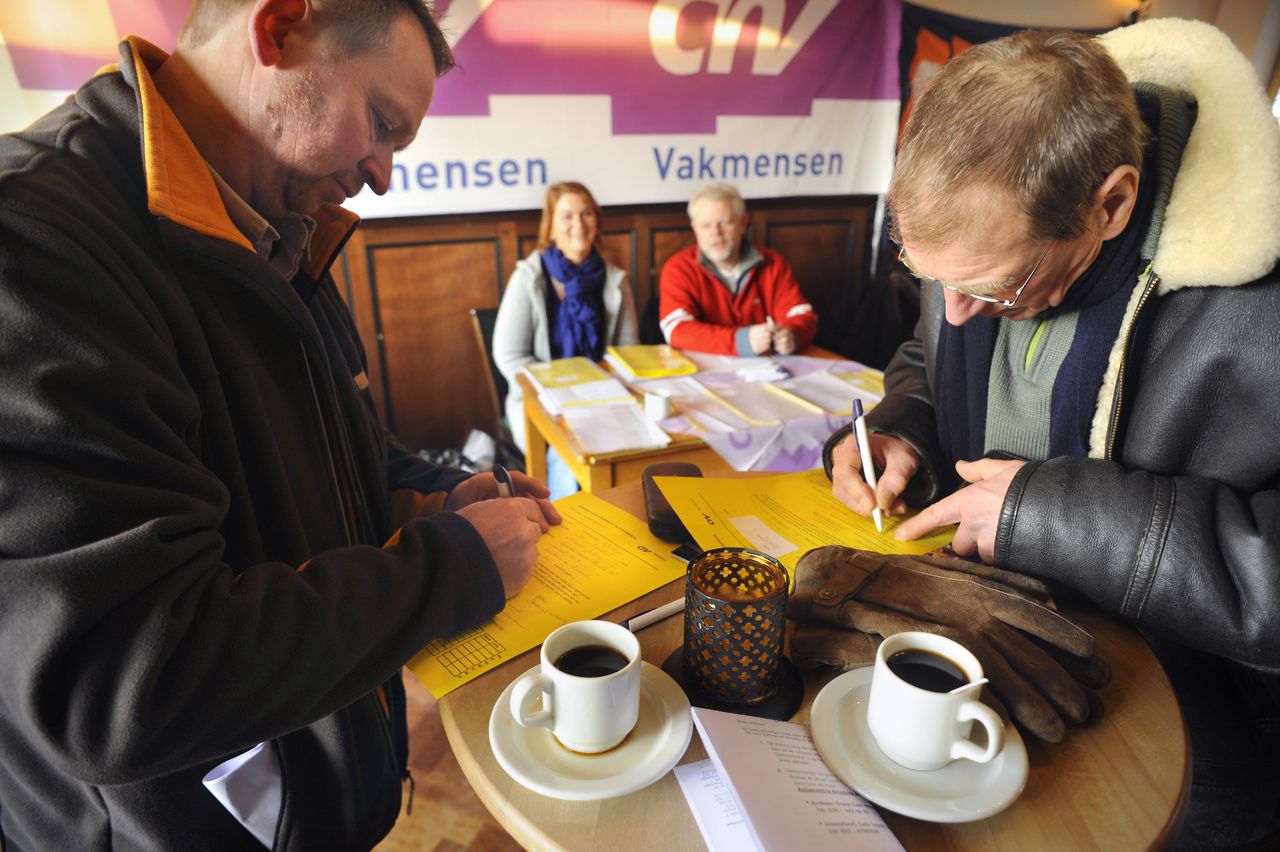 Werknemers van AkzoNobel schrijven zich in als staker in een café in Arnhem. De vakbonden hielden gisteren een 24-uursstaking bij het verf- en chemiebedrijf. Foto Flip Franssen Nederland, Arnhem, 26-1-2010 Werknemers van AKZO schrijven zich in als staker in een zaaltje van cafe Metropole in Arnhem. Foto Flip Franssen