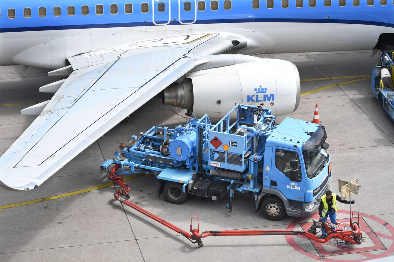 Grondpersoneel op Schiphol is bezig met het tanken van een vliegtuig.