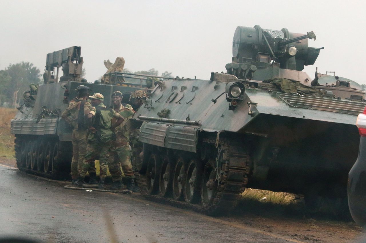 Soldaten staan bij militaire voertuigen, net buiten de Zimbabweaanse hoofdstad Harare op dinsdag.