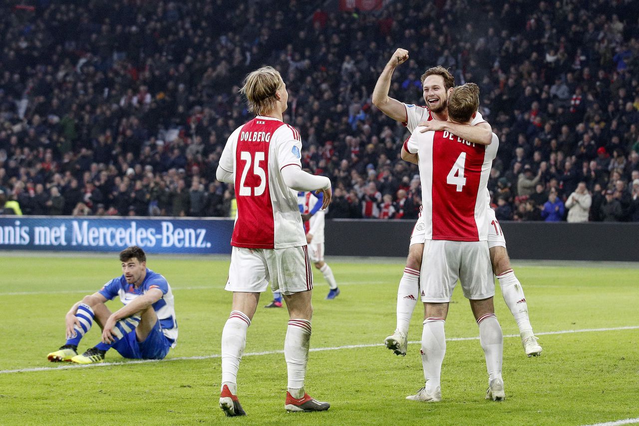 Ajax-verdediger Daley Blind wordt gefeliciteerd na een doelpunt tegen De Graafschap door ploeggenoten Matthijs de Ligt en Kasper Dolberg.