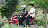 Menteri Pertahanan Indonesia Prabowo Subianto, yang memenangkan pemilihan presiden, mengendarai sepeda motor polisi saat mengunjungi makam ayahnya.  Foto oleh Tatan Syuflana