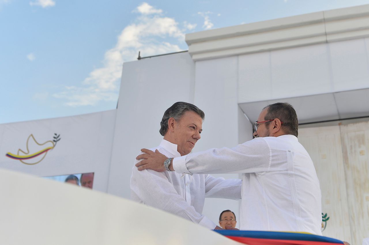De Colombiaanse president Juan Manuel Santos (l) schudt Farc-leider Rodrigo Londono de hand na de ondertekening van het vredesakkoord op 26 september.