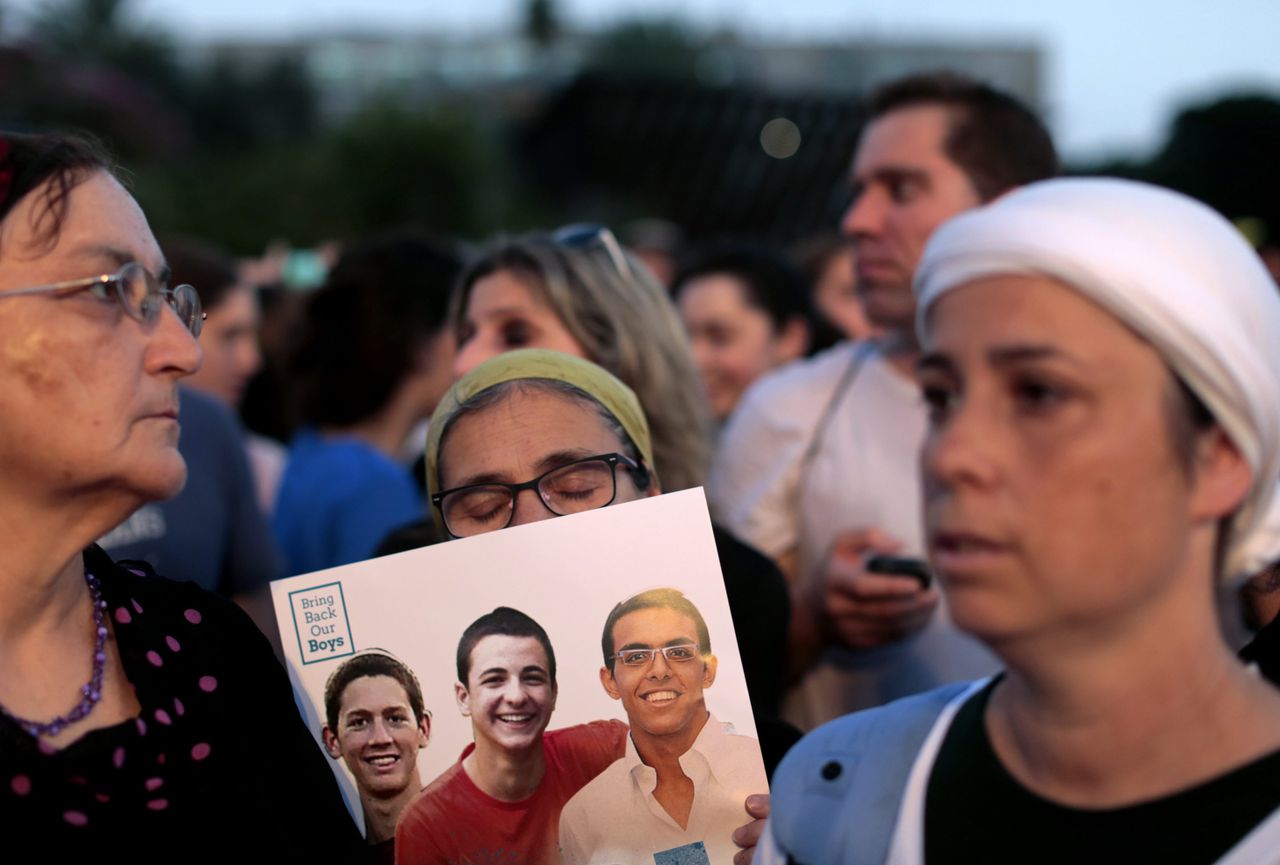 Demonstranten houden een foto van de vermoorde Israëlische tieners omhoog
