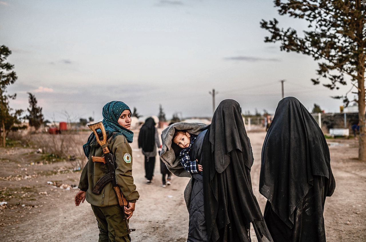 Bewaakster met vermoedelijke vrouwen van IS-strijders in een kamp van de Syrian Democratic Forces (SDF) in het noordoosten van Syrië.