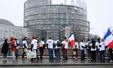 A farmer holds a sign which reads "we don't shout, we feed" during a demonstration against the EU-Mercusor trade agreement, outside the European Parliament in Strasbourg, eastern France, Tuesday, Jan. 20, 2026. (AP Photo/Pascal Bastien)