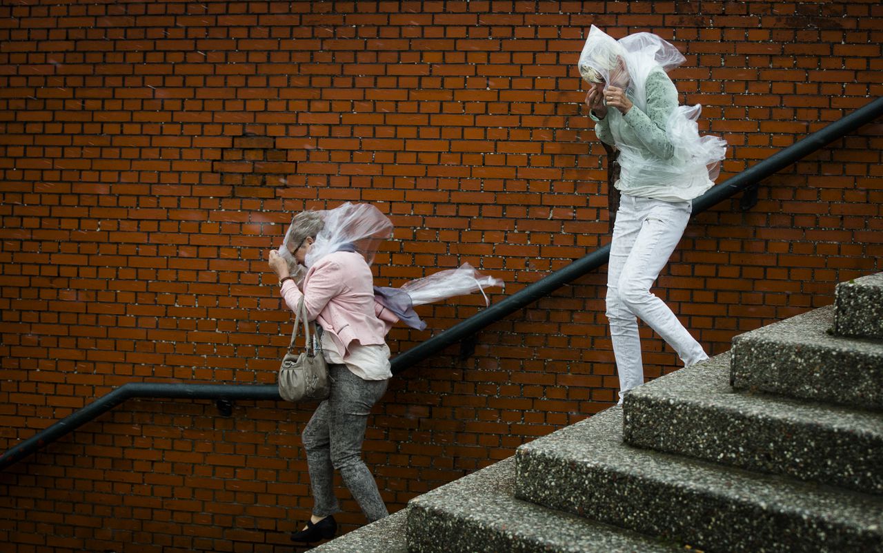 Twee vrouwen trotseren de harde wind bij de boulevard van Scheveningen afgelopen zaterdag. Een groot pand aan de rand van een dorp of stad in het westen van het land is de meest kwetsbare plek in Nederland tijdens een storm.