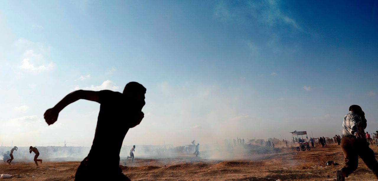 Palestijnen zoeken dekking als er dinsdag vanuit een Israëlische drone traangas wordt afgevuurd in het oosten van Gaza-Stad.