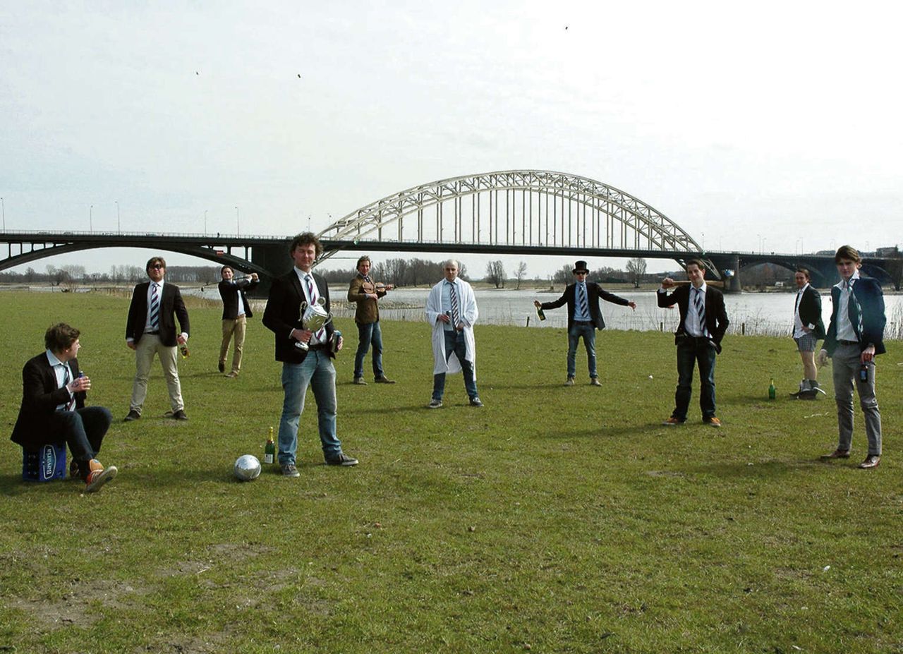Max, in het midden, in witte ochtendjas, met middelbareschoolvrienden voor de Nijmeegse Waalbrug.