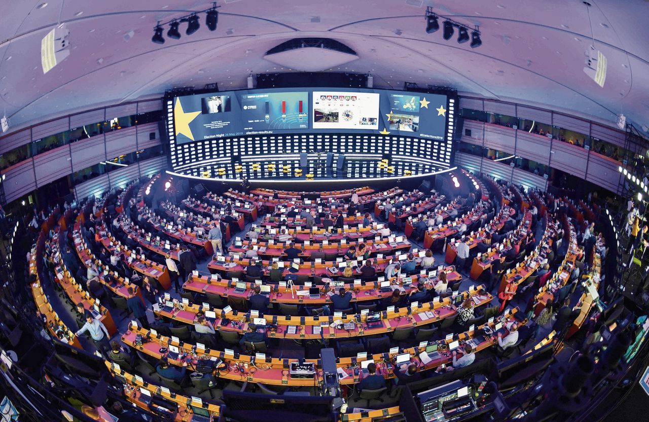 In de plenaire vergaderzaal van het Europese Parlement bekijken journalisten de uitslagen van de verkiezingen op een videowall.