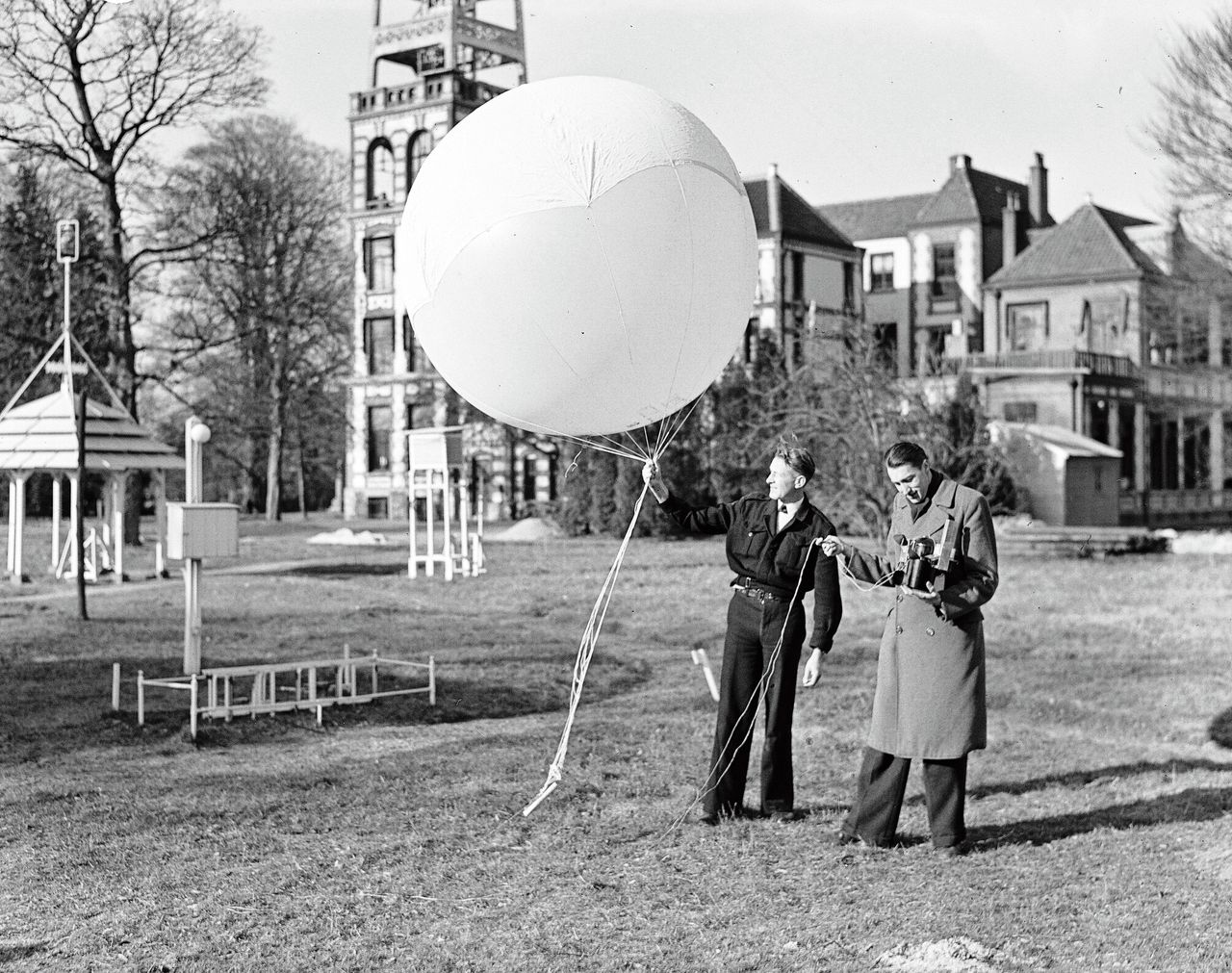KNMI-wetenschappers laten in 1948 een weerballon op. Geheel links de oude pagodehut. In het midden een Stevensonhut.