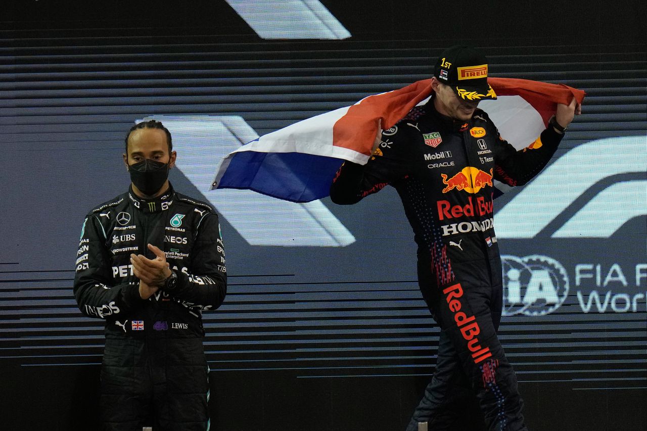 Lewis Hamilton (links) applaudisseert voor de nieuwe wereldkampioen Max Verstappen.