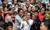 Zittend president Joko Widodo  maakt een selfie  nadat hij de verkiezingen heeft gewonnen.