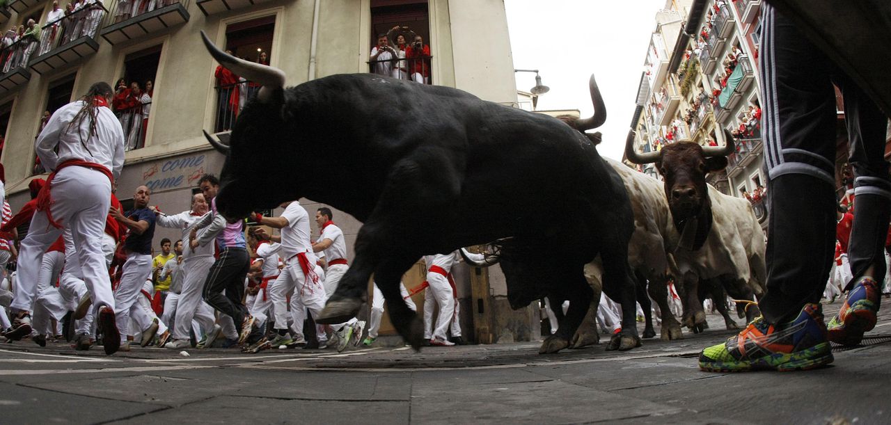 Rennende stieren en mensen tijdens het jaarlijkse San Ferminfestival in Pamplona.