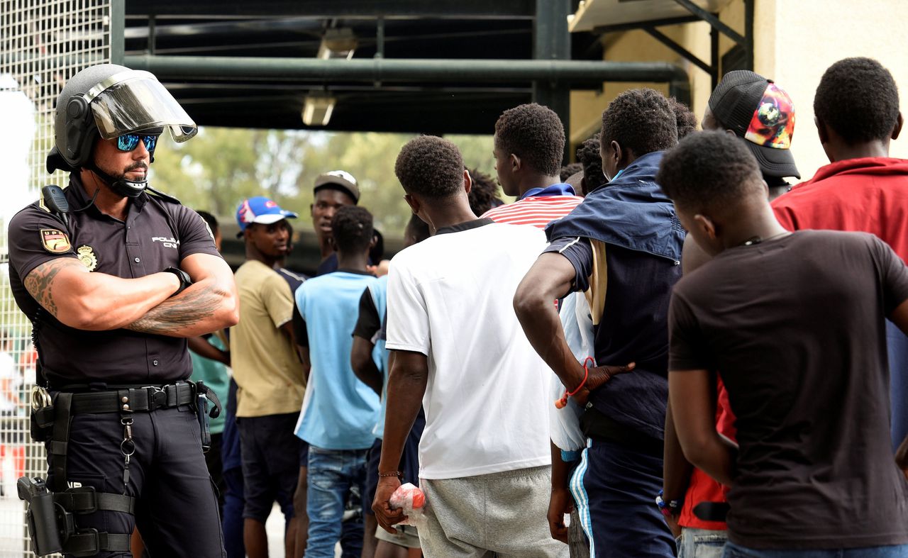 Afrikaanse migranten wachtten woensdag, in een rij, na aankomst in de Spaanse exclave Ceuta.