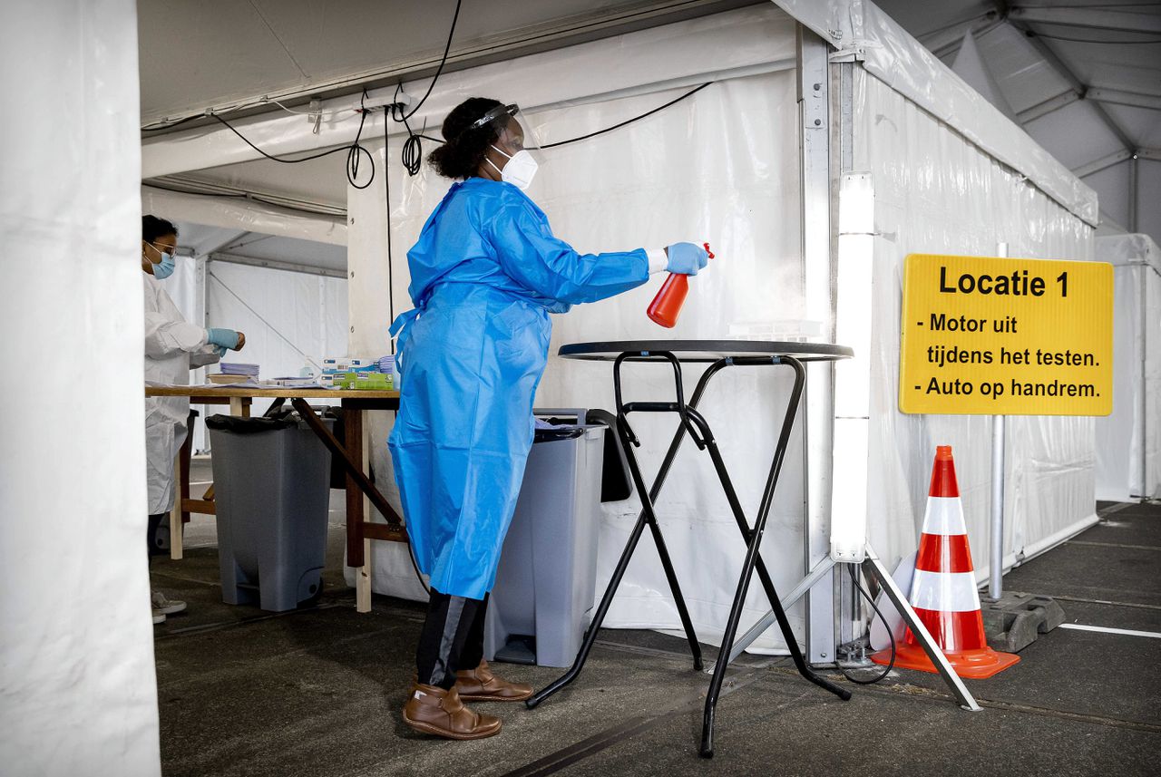 Een medewerker van de GGD Rotterdam-Rijnmond neemt een coronatest af in een teststraat.