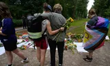 Rouwende mensen omhelzen elkaar nabij de plek van de aanslag in Berlijn.