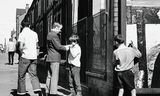 Een jongen krijgt een vuurtje voor een sigaret in Bootle, een voorstad van Liverpool, in 1968. 