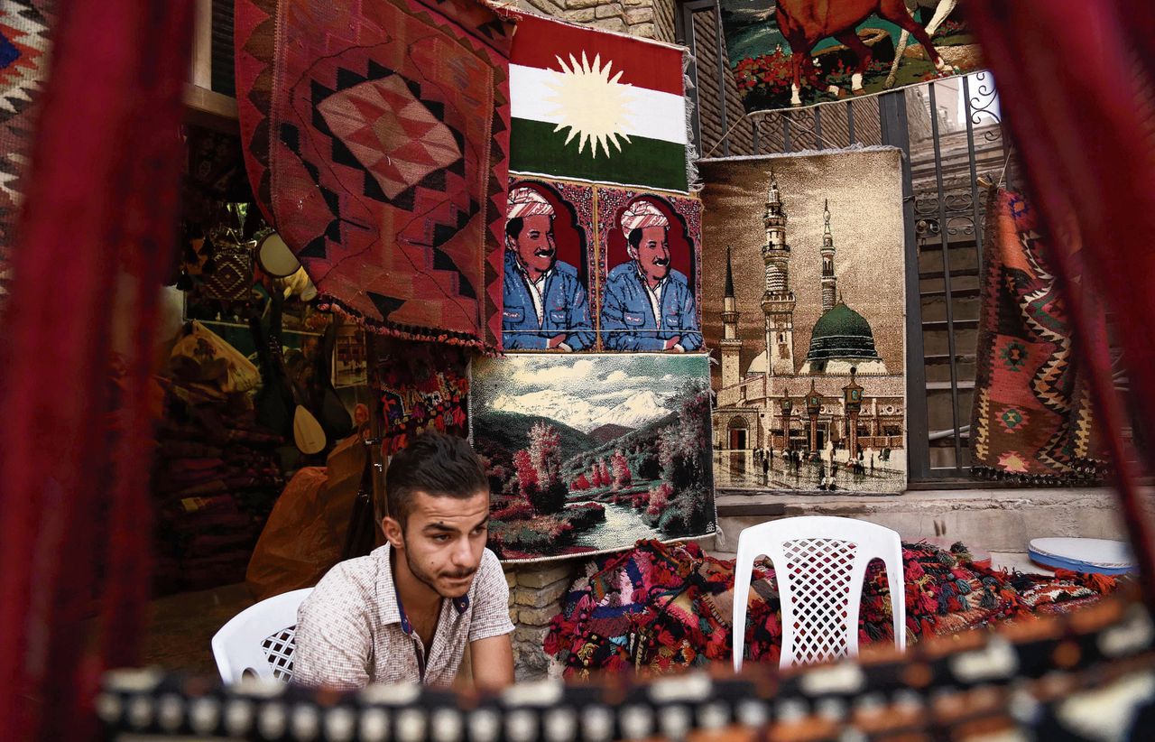 Winkelier in Erbil, hoofdstad van de Koerdische regio in Irak. Hij verkocht zondag nog tapijten met de afbeelding van president Barzani, die vertrekt.
