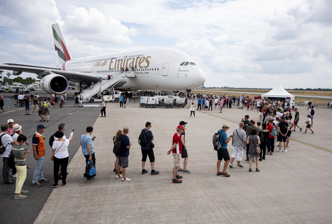 Bezoekers van een luchtvaartbeurs in Duitsland bekijken een Airbus A380 van Emirates.
