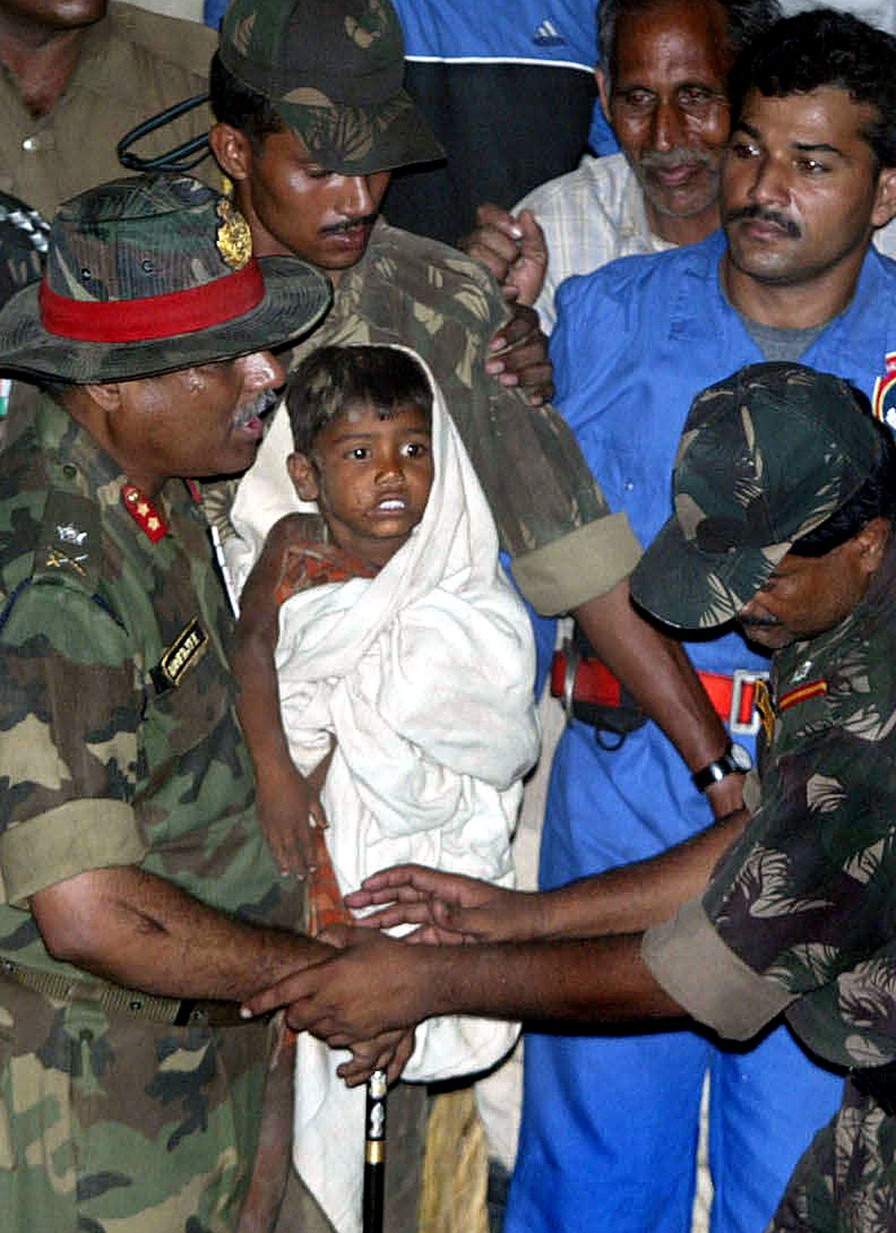 ** ALTERNATE CROP ** Soldiers carry Prince, 6, after he was rescued from an 18-meter-deep (60-foot-deep) hole, at Aldeharhi, in the northern Indian state of Haryana, Sunday, July 23, 2006. Soldiers carried a 5-year-old boy back to ground level Sunday, bringing to an end the child's 50-hour ordeal. The Indian nation was gripped by the dramatic rescue with some channels suspending regular coverage to devote nearly all their air time to the rescue effort. (AP Photo/Mustafa Quraishi)