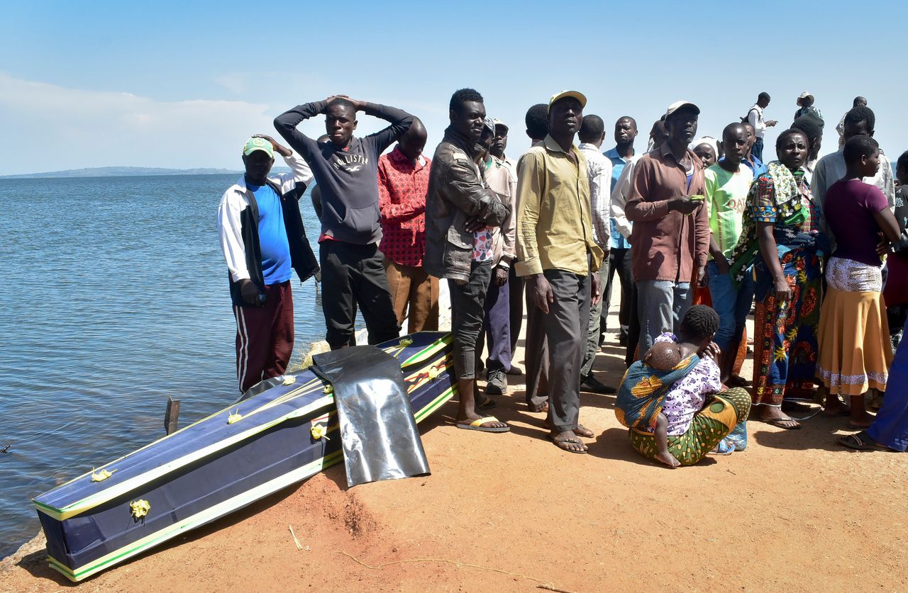 Familieleden van de slachtoffers van de MV Nyerere veerboot staan zaterdag naast een lege grafkist op het eiland Ukara.