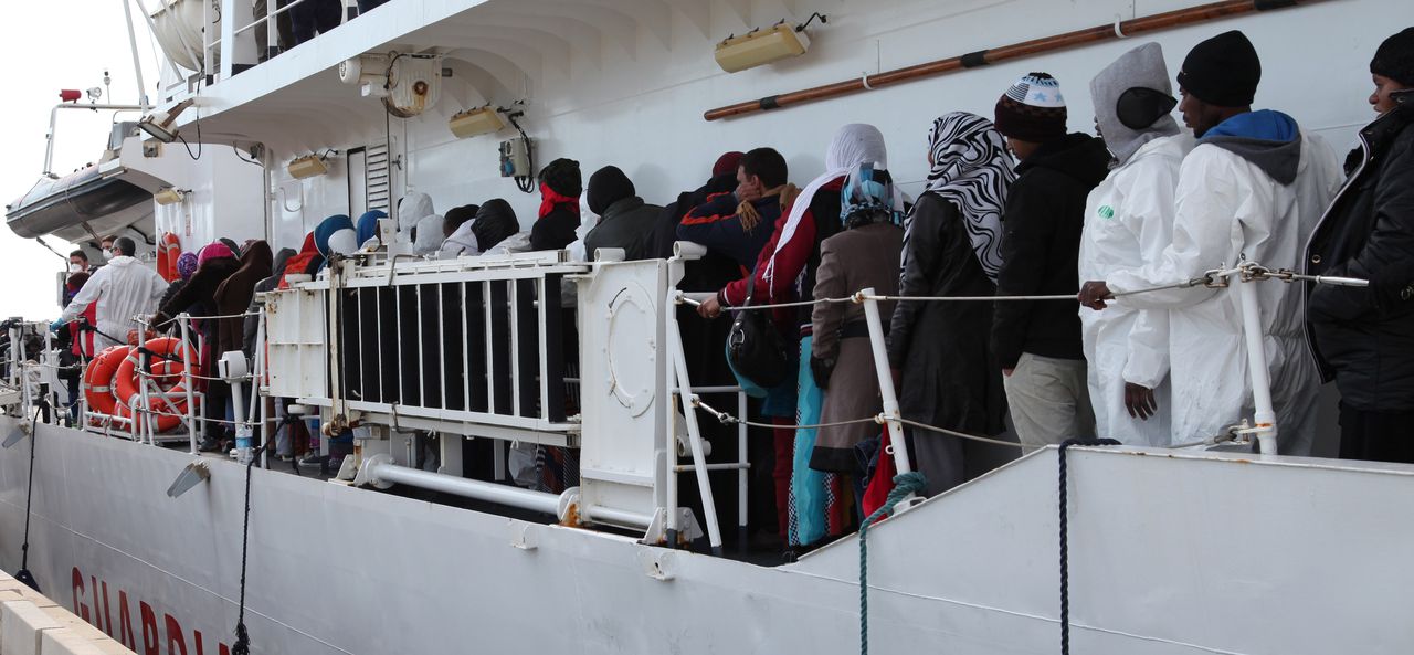 Migranten op een boot van de Italiaanse kustwacht in Porto Empedocle, Sicilië.