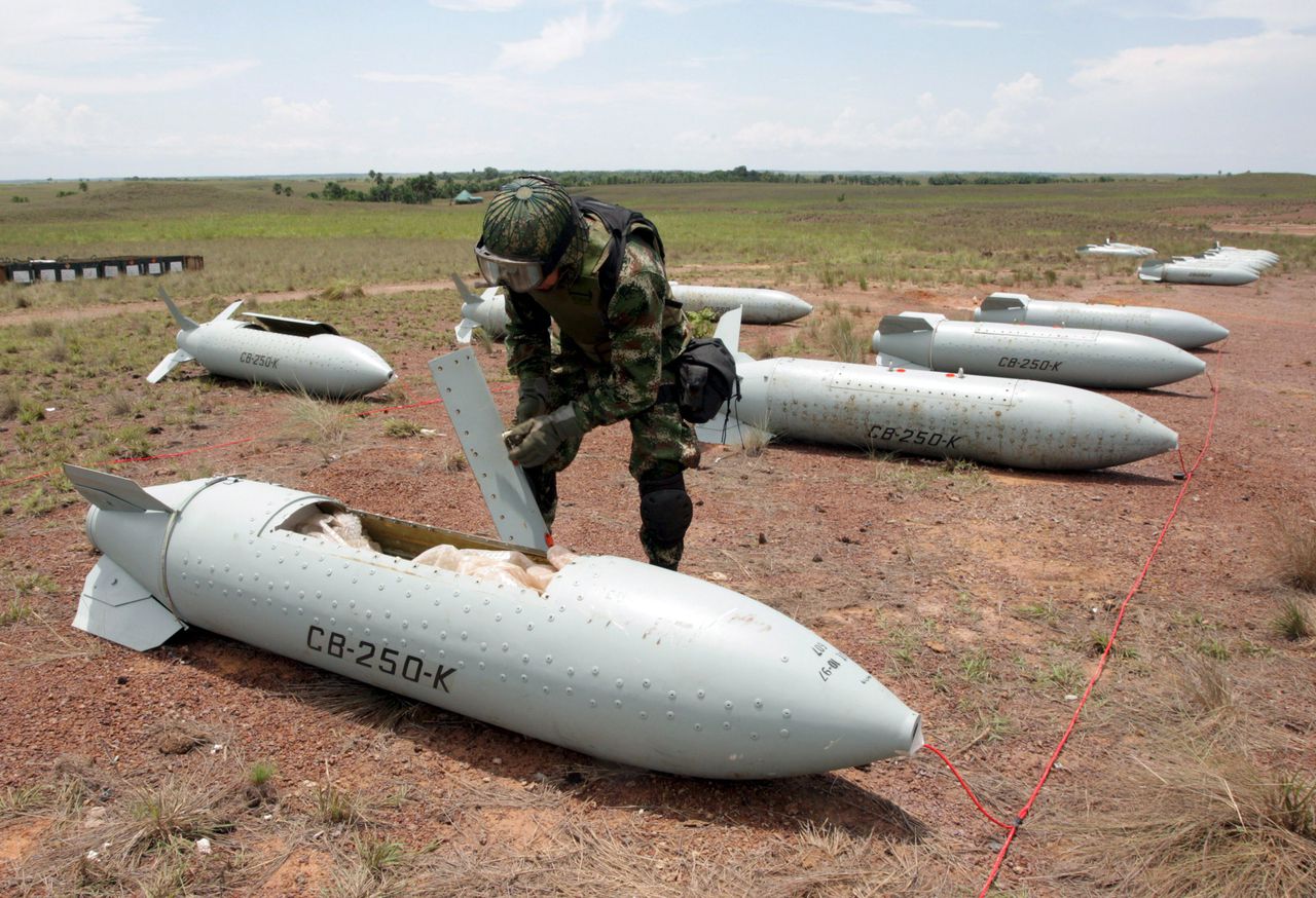 Een medewerker van de Colombiaanse luchtmacht controleert een clusterbom voordat deze wordt vernietigd