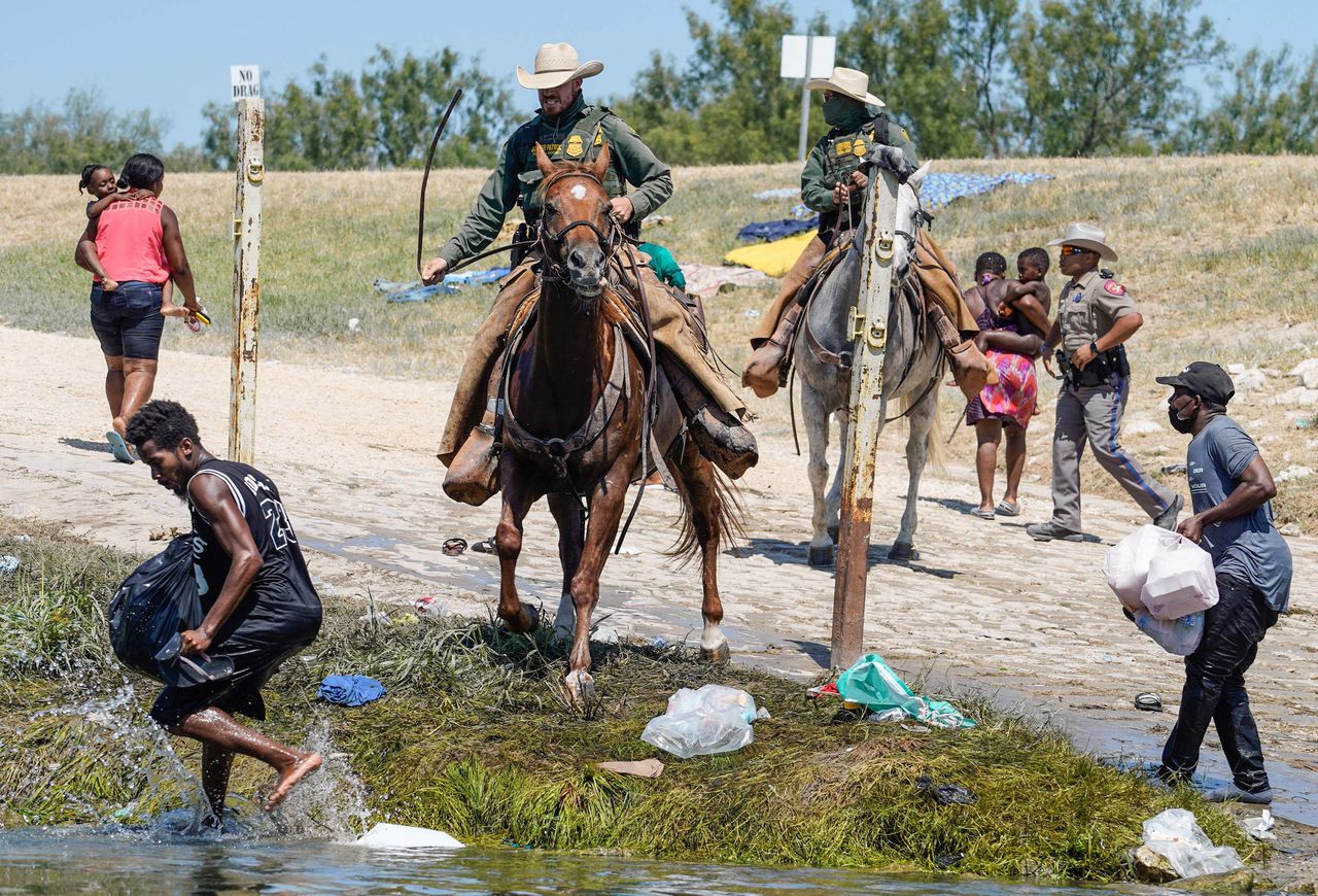 Amerikaanse grenswachten te paard jagen Haïtiaanse migranten in Texas op, om te voorkomen dat zij een vluchtelingenkamp bereiken.