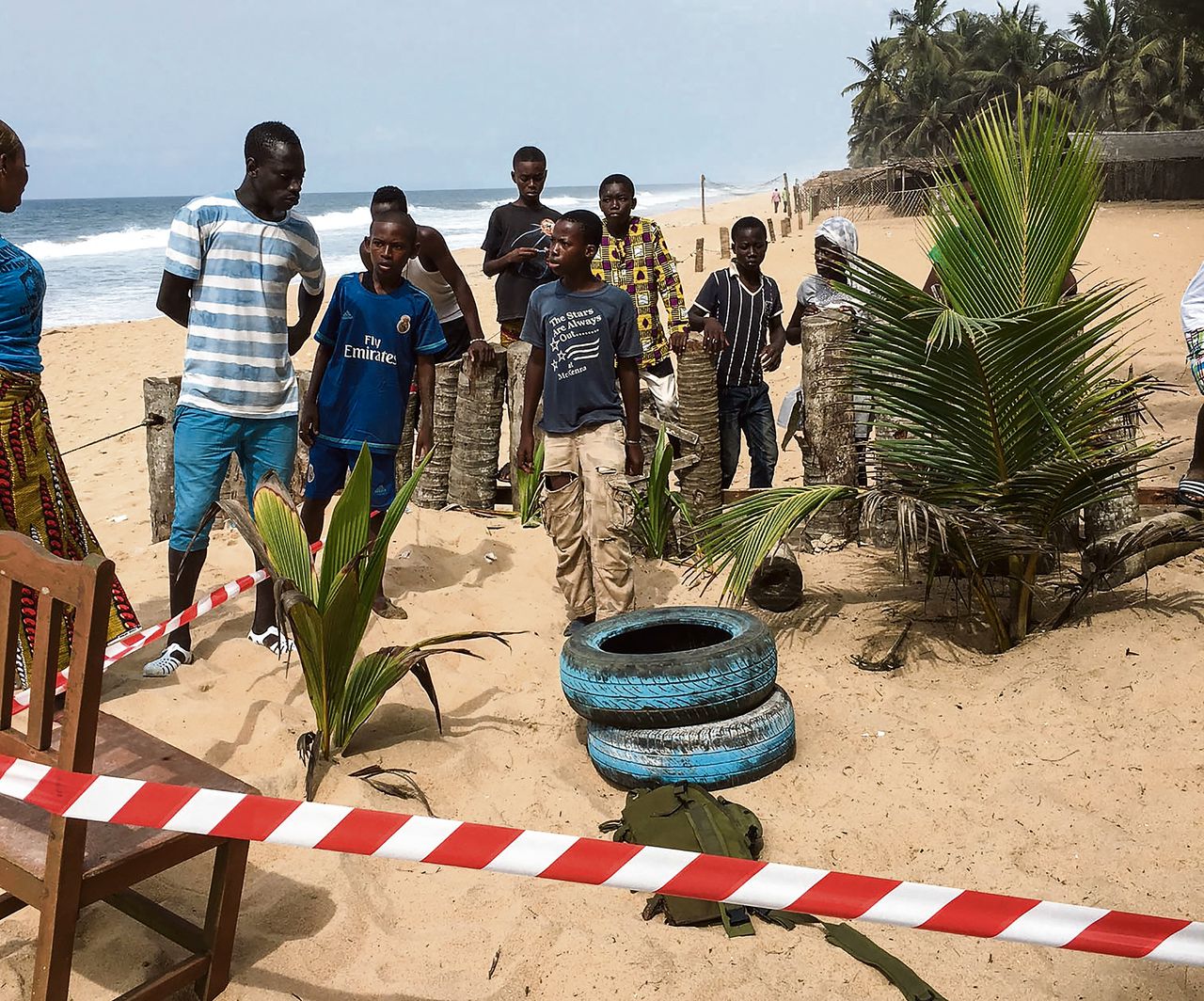 Ivorianen kijken toe op het strand van Grand Bassam, waar zondag 22 mensen werden neergemaaid.