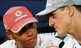 Lewis Hamilton  (links) in 2010 in gesprek met Michael Schumacher voor de Grand Prix van Japan.