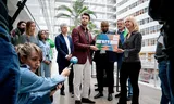 In het Haagse stadhuis wordt een petitie aangeboden aan raadsleden tegen het stopzetten van de subsidie voor Kringloop Schroeder. Foto Bart Maat