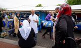 Op het Afrikaanderplein in Rotterdam vraagt huisarts Bunyamin Meral of de marktbezoekers al gevaccineerd zijn.