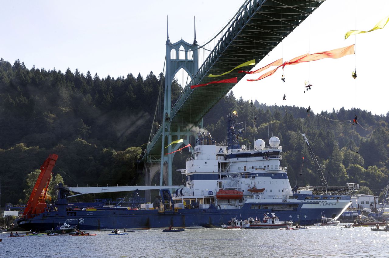 Juli 2015, de ijsbreker Fennica van Shell vaart over de rivier Willamette in Portland. Op de brug protesten tegen de olieboringen.