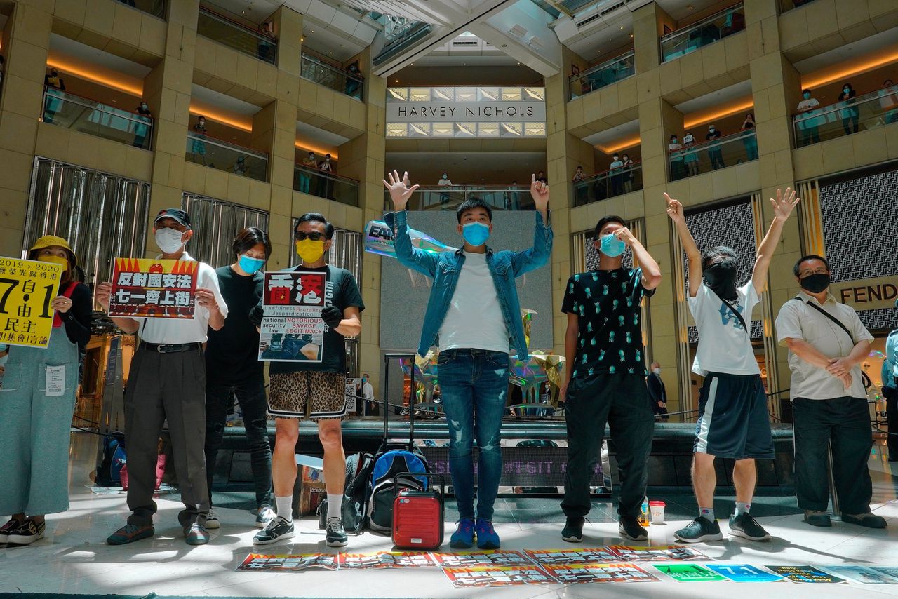 Activisten in een winkelcentrum in Hongkong roepen op om woensdag, de datum van de machtsoverdracht in 1997, te protesteren tegen de nieuwe veiligheidswet.