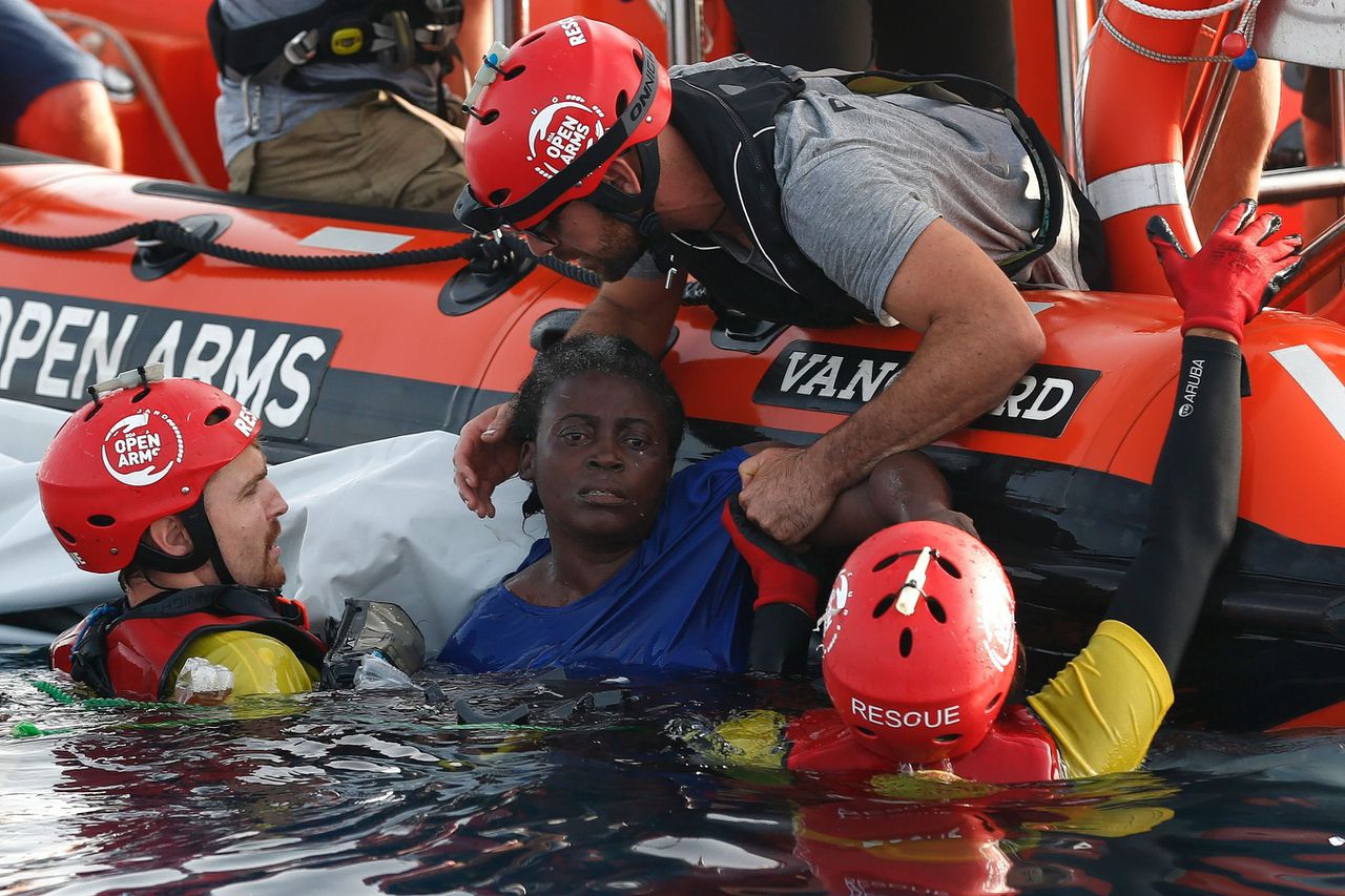 Een derde migrant, die ook op de verwoeste rubberboot ronddobberde, heeft het overleefd en wordt hier door reddingswerkers uit het water gehaald.