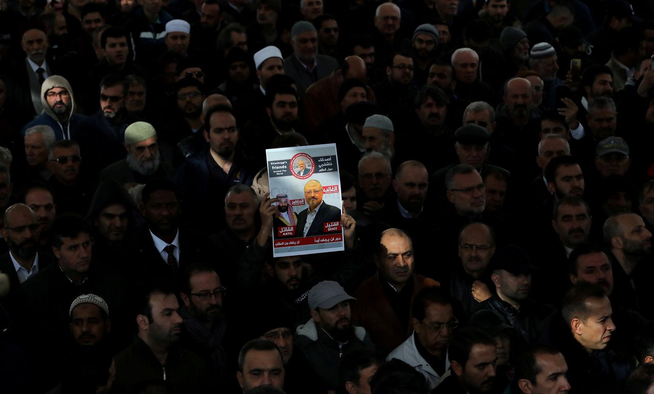 Bezoekers van een plechtigheid op 16 november in een moskee in Turkije ter ere van journalist Jamal Khashoggi houden een bord met zijn afbeelding omhoog.