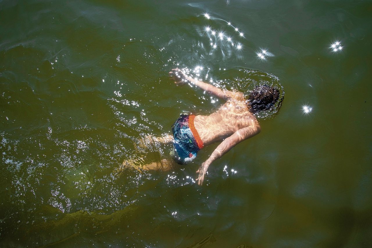 Voor natuurzwembad De Kuil in Prinsenbeek in Noord-Brabant geldt een waarschuwing voor blauwalg. Bezoekers trekken zich daar weinig van aan. „Ik ga ervan uit dat als zwemmen gevaarlijk wordt, ze het bad sluiten”, zegt vader Frank Schalk.